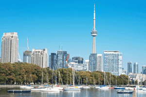 A picturesque scene of boats floating on water with a city skyline in the backdrop