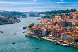 A scenic river with boats sailing and a cityscape in the background, showcasing the beauty of urban waterfront