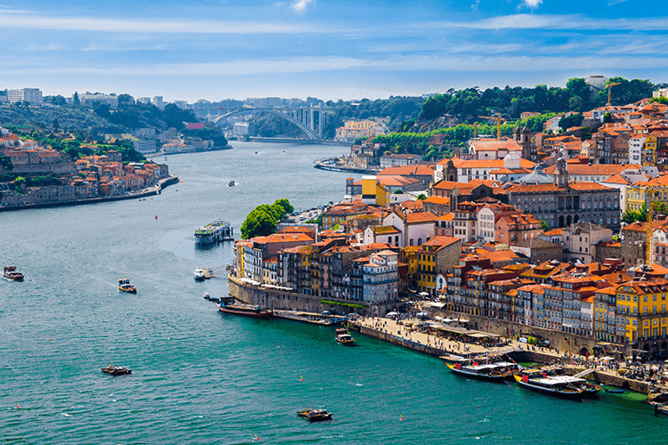 A scenic river with boats sailing and a cityscape in the background, showcasing the beauty of urban waterfront