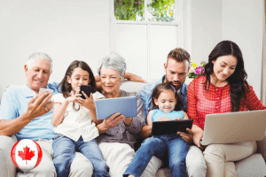 A Canadian family engrossed in technology, using a laptop and tablet for various activities