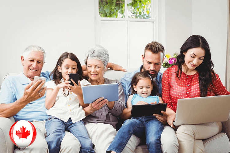 A Canadian family engrossed in technology, using a laptop and tablet for various activities