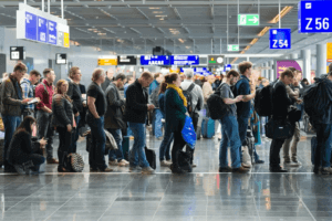 Passengers standing in an orderly queue at the airport, eagerly awaiting their turn to check-in or board their flights