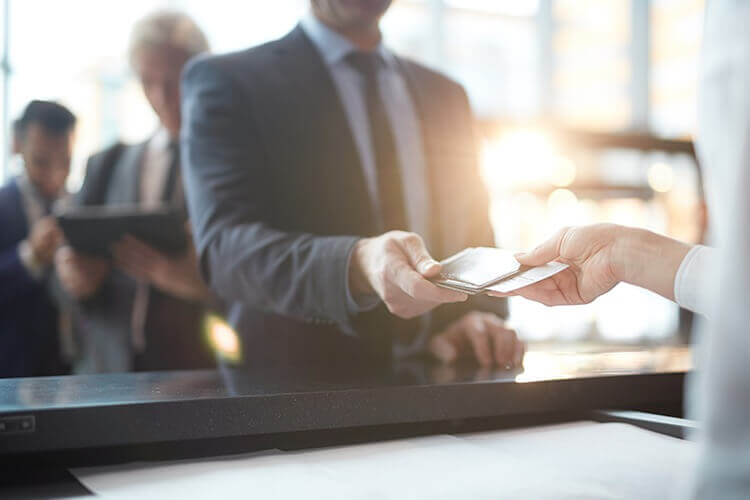A man in a suit passing a passport to another person
